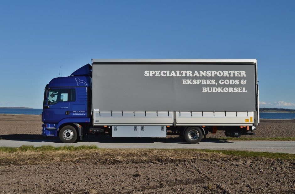 Lastbilen holder i et åbent landskab med kysten i baggrunden